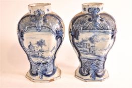 A pair of 19th century Delft baluster vases, each painted with a house in a landscape, marked,