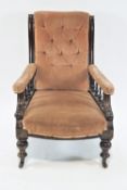 A Victorian mahogany framed armchair with button back on turned legs with ceramic casters,