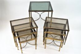 A pair of nests of three brass tables with glass tops,
