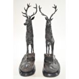 A pair of bronze figures of stags seen in an alert pose on a crag and raised on marble bases,