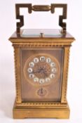 A 19th century gilt and four glass carriage clock with enamel Arabic numerals above an alarm dial