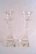 A pair of glass candlesticks of multi facet cut baluster form raised on square feet.
