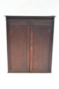 A 19th century oak hanging wall cabinet with two panelled doors,