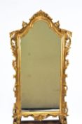 A wall mirror in a carved and gilded Rococo style frame, 103cm high,