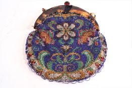 A beaded bag of rounded form, decorated with floral motifs and set with a faux tortoiseshell clasp,