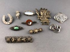 A collection of ten white metal brooches of various designs,
