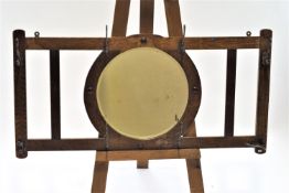 An oak framed hanging coat rack, with central round mirror, 61cm high,122cm wide,