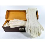 A leather box containing two pairs of kid elbow length evening gloves and others