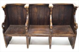 An oak three seat choir stall, the arms pierced with trefoils, 100cm high, 167cm wide,