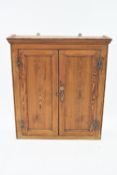 A Victorian pine panelled two door hanging cabinet,