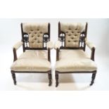 A pair of Victorian mahogany and button back armchairs with turned legs on casters, 86cm high,