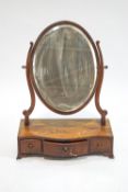 A George III mahogany swing frame mirror on serpentine box base with three freeze drawers
