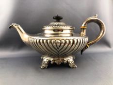 A silver low form semi fluted tea pot with domed lid and set a silver handle