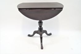 A mahogany tripod table with drop leaves,
