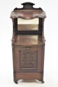 A Victorian mahogany coal purdonium, with raised mirrored back above a carved panel on casters,