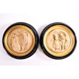 A pair of resin plaques of tondo of rondel form with cameo scenes of lovers in rural landscapes,