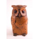 A carved owl tobacco box, in light wood, the hinged head lid set with amber glass eyes,