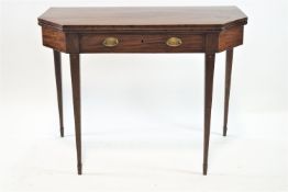 An Edwardian mahogany foldout tea table with cut corner rectangular top set a frieze drawer