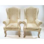 A pair of 20th century wing back armchairs on carved and painted legs, 82cm high, 92cm wide,