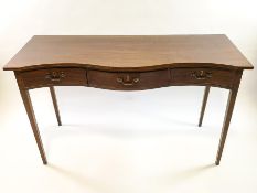 A mahogany sewing table with serpentine front with three drawers on square tapering legs,