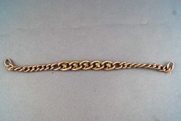 A yellow metal hollow curb link bracelet having a central shamrock design to five links
