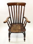 A 19th century Windsor chair of traditional form, with shaped elm seat supporting the arms,