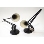 Two black anglepoise lamps with round bases,