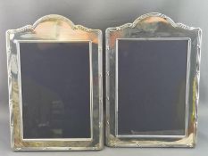 A pair of silver dome topped rectangular photograph frames with ribbon and reed edging,
