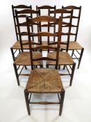 A set of six stained beech ladder back chairs, with rush seats,