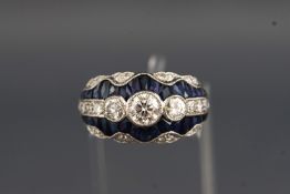 A white metal dress ring set with a central round brilliant cut diamond