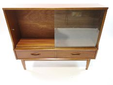 A teak side cabinet, with two sliding glass doors above two drawers,