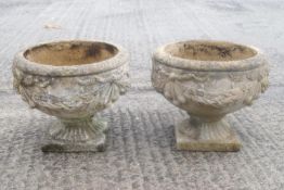 A pair of composit round garden urns,