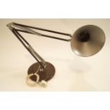 A brown anglepoise lamp with round base,