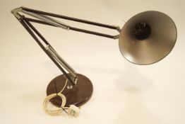 A brown anglepoise lamp with round base,