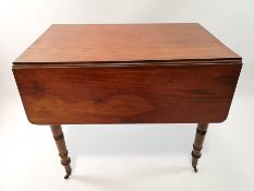 A 19th century mahogany Pembroke table on turned and tapering legs with brass casters,