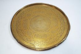 A Middle Eastern brass tray, of round form, with typical decoration,