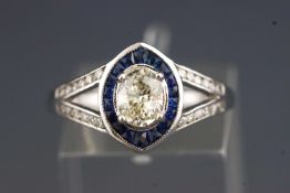 A white metal dress ring. Set with a central oval diamond of approximately 0.60cts.