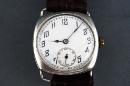 A white metal unbranded wristwatch. Cushion case with white dial and Arabic numerals.