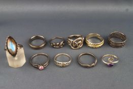 A collection of ten white metal rings of variable designs ranging in size from J to Q.