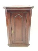 A 19th century oak hanging corner cabinet with two panelled doors,