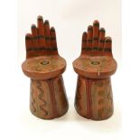 A pair of possibly South American stools, carved and painted as open hands,