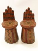 A pair of possibly South American stools, carved and painted as open hands,
