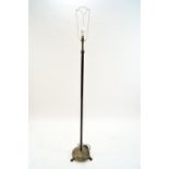 A brass standard lamp with fluted column on round base on three paw feet,