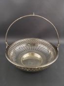 A white metal swing handle sweet meat basket, the round bowl with pierced decoration,