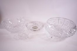 A round cut glass bowl on three feet, another bowl and two ash trays,