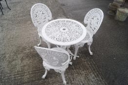 A white 1970's patio set with three chairs