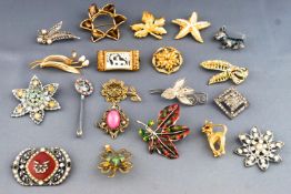 A collection of twenty costume brooches of variable designs.