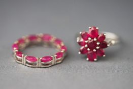 A white metal cluster ring set with round and oval cut composite (glass filled) rubies,