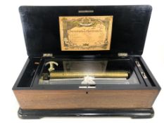 A 19th century inlaid walnut and scumbled wood German ten air cylinder music box with crank handle