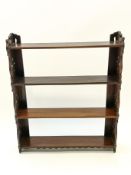 A 19th century mahogany four tier wall shelf with pierced sides,